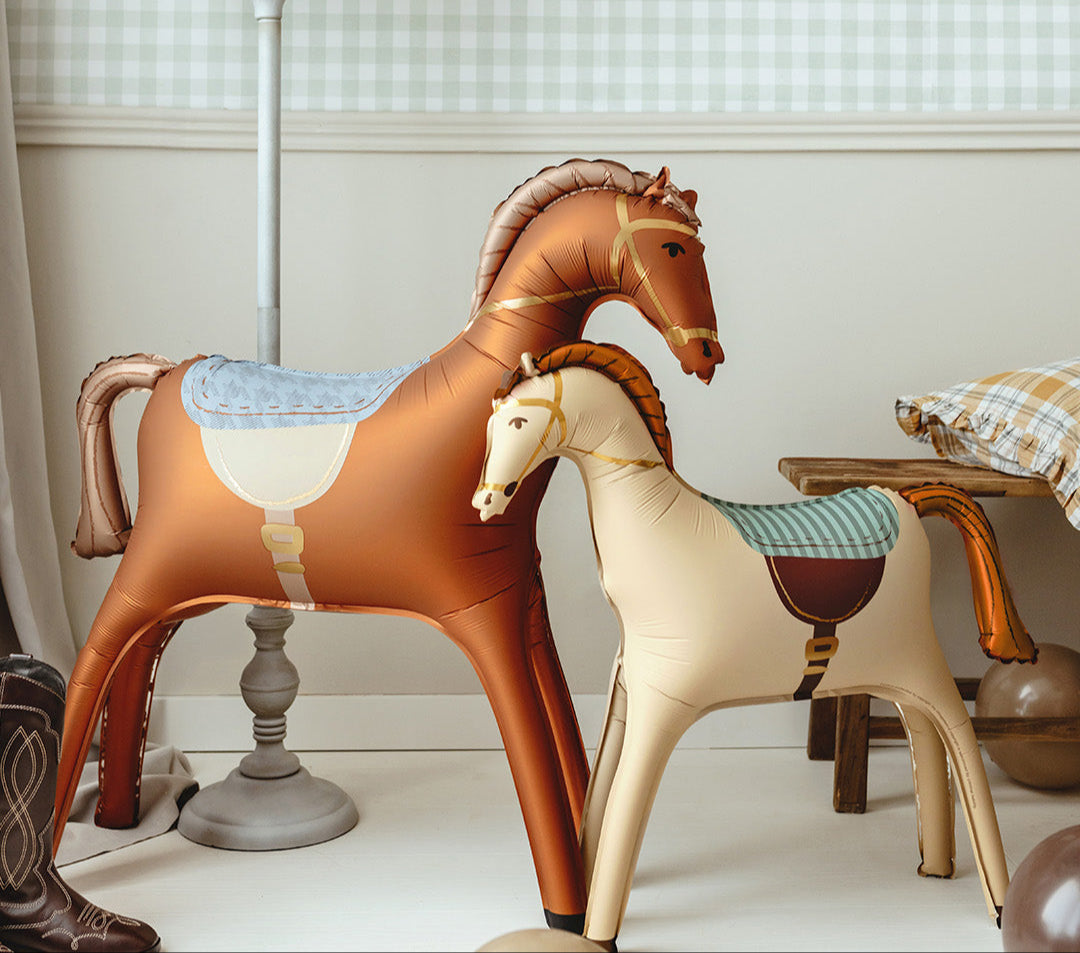 Horse Club birthday party decorations, brown horse balloon, pastel balloons, Happy Birthday garland, and themed tableware in soft pink and blue colors