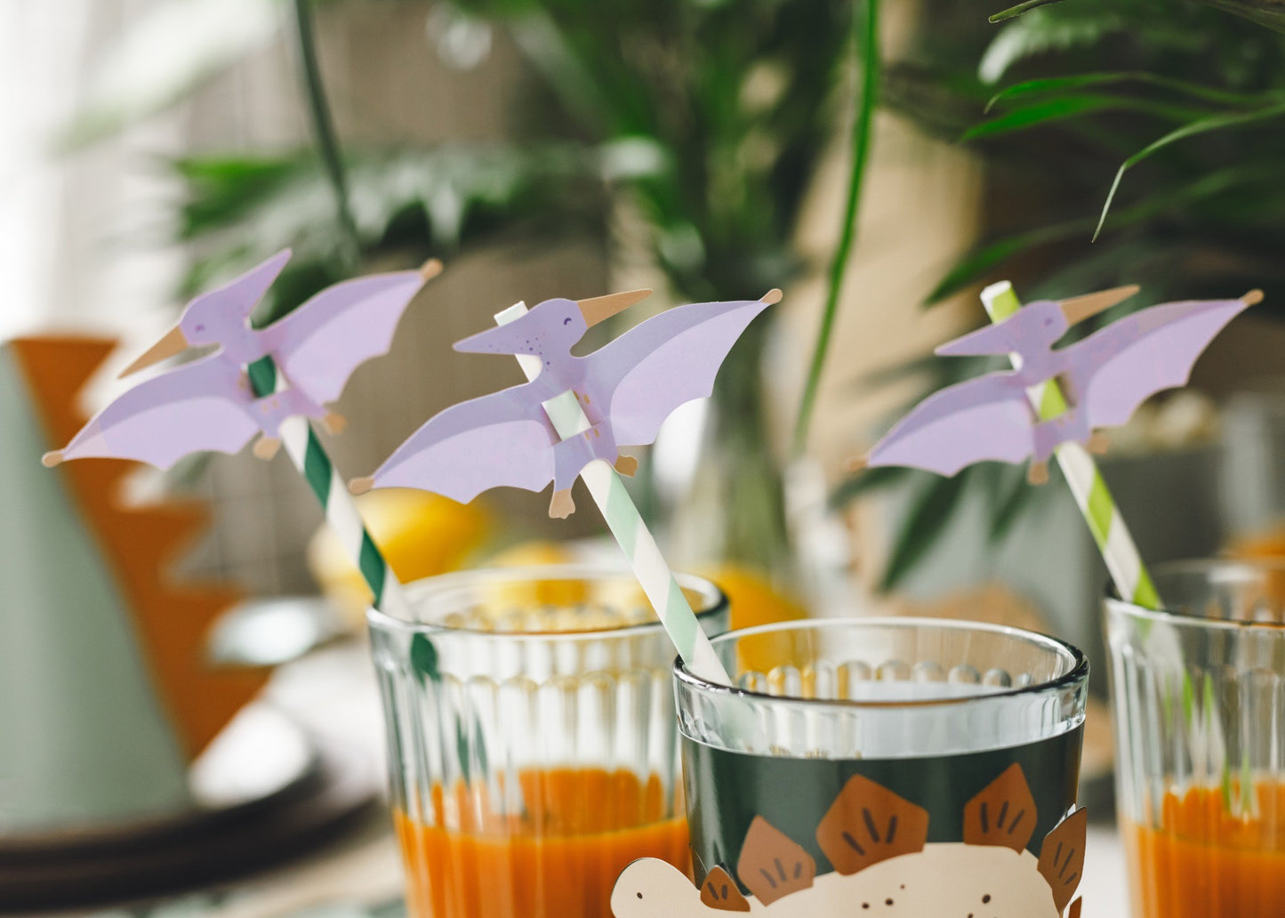 Set of green and white striped dino paper straws with pterodactyl toppers