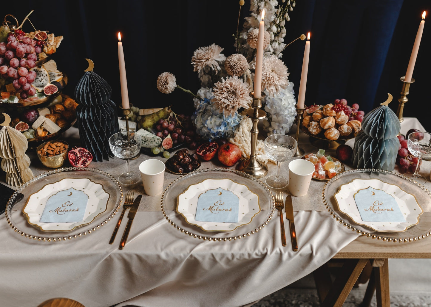 Decorative table setting with place cards, candles, and fruit arrangement.