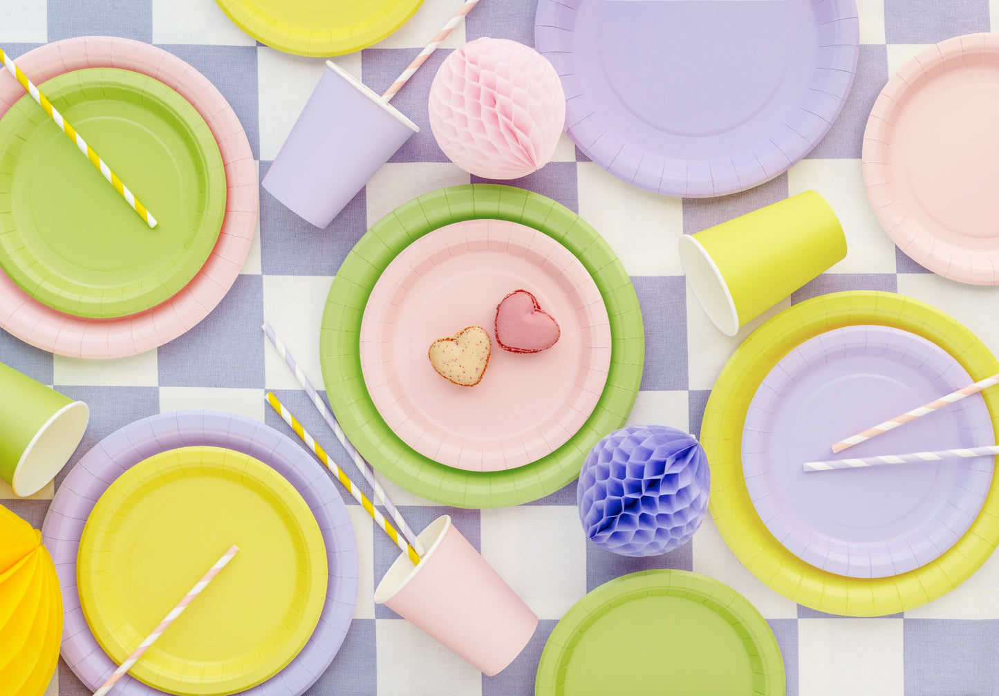 Colorful paper plates and cups on a checkered tablecloth