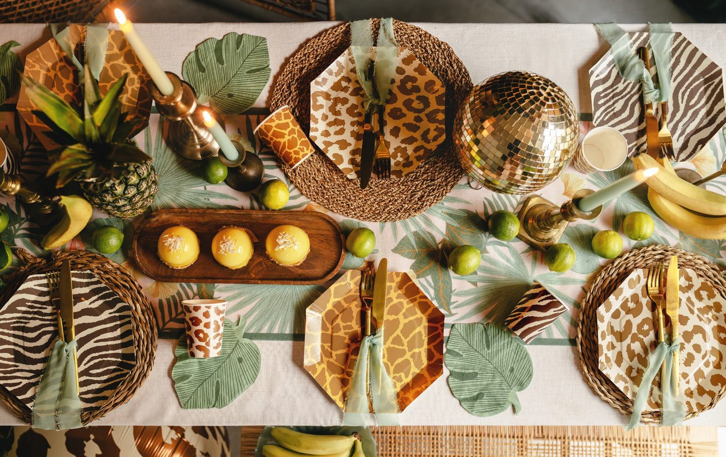Decorative table setting with animal print plates, gold accents, and greenery.