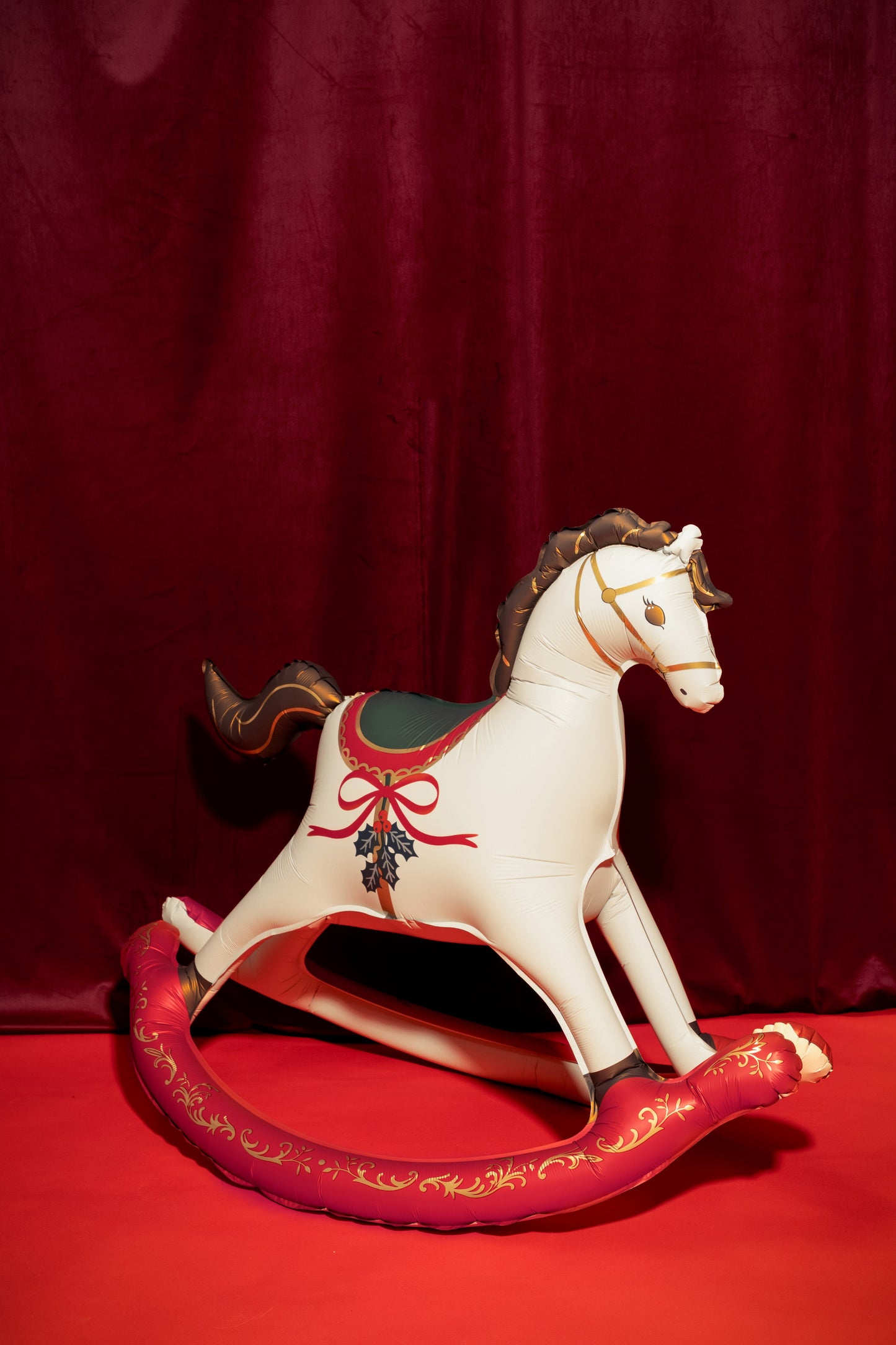 Decorative rocking horse with red base on a red background