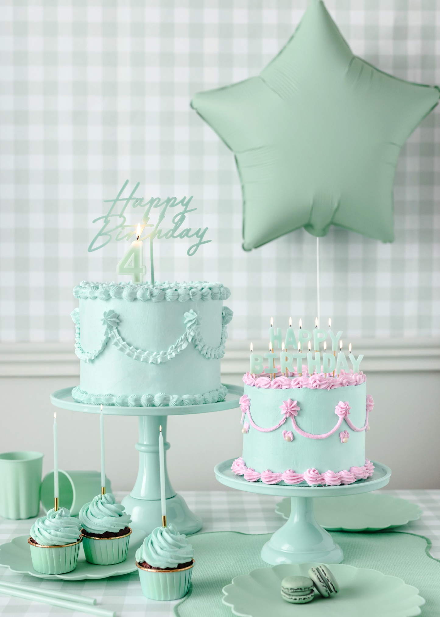 Mint green birthday party decor with star balloon, pastel cakes, pink icing details, and coordinated cupcakes and tableware