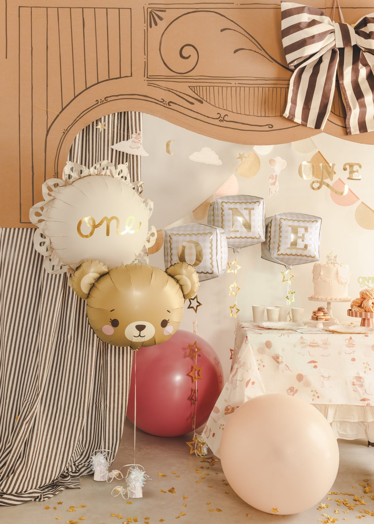 Decorative setup with balloons and a teddy bear head on a table.