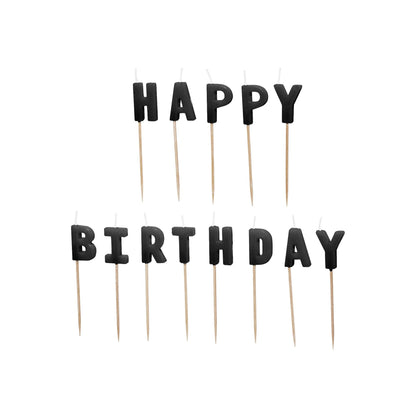 Black 'Happy Birthday' letter candles on wooden sticks against a white background
