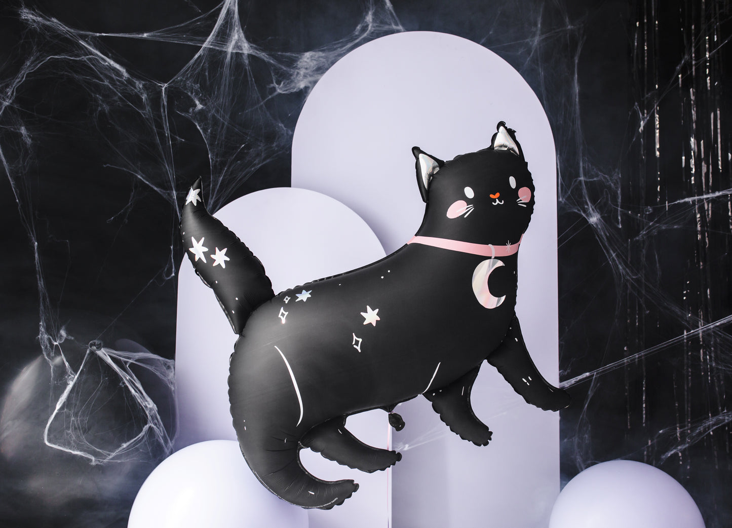 Black cat foil balloon with star and moon designs on a dark background