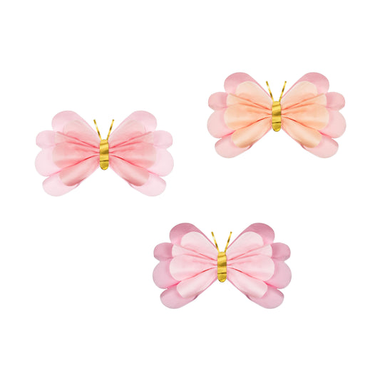 Three pink butterfly-shaped paper deco on a white background