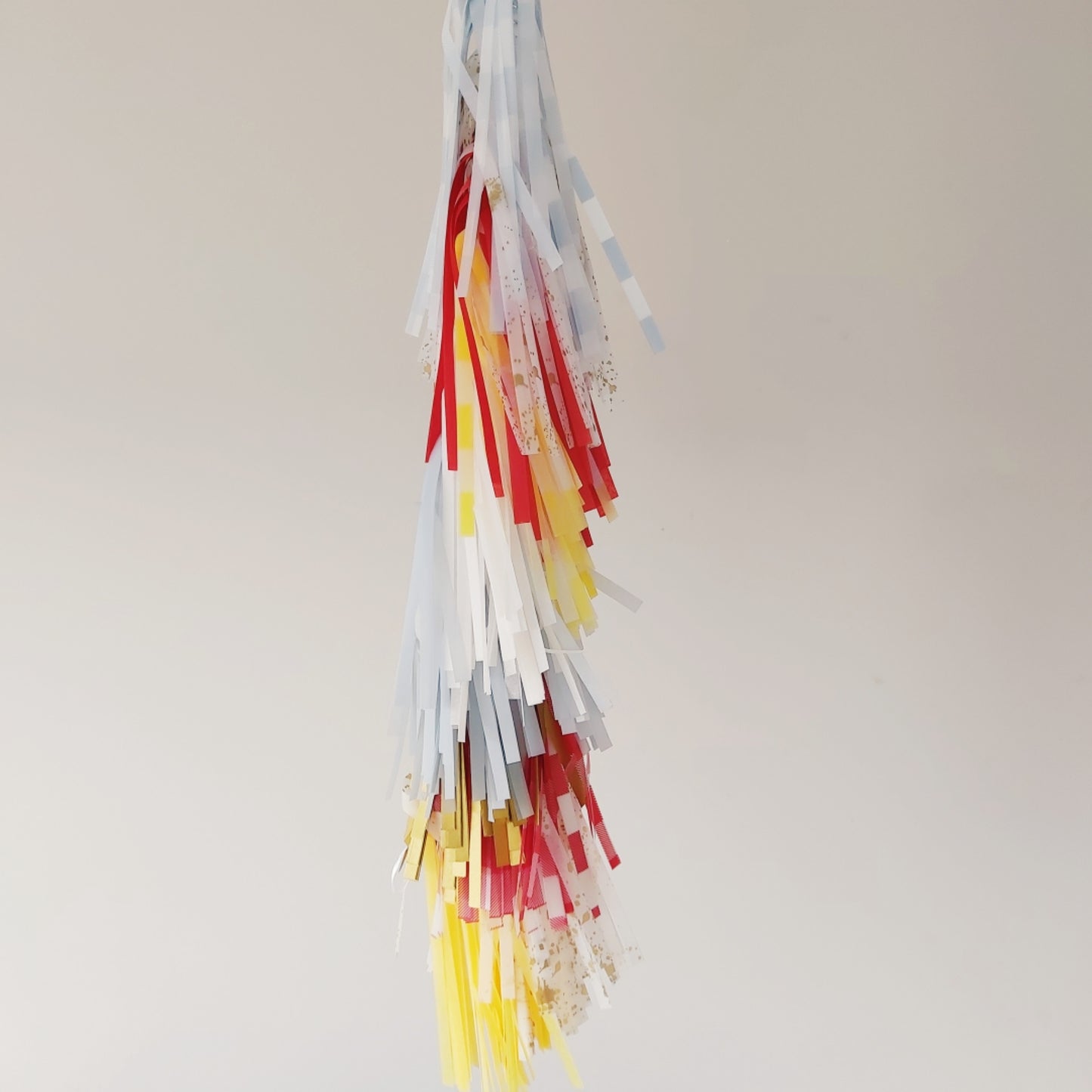 Colorful paper streamers hanging against a plain background