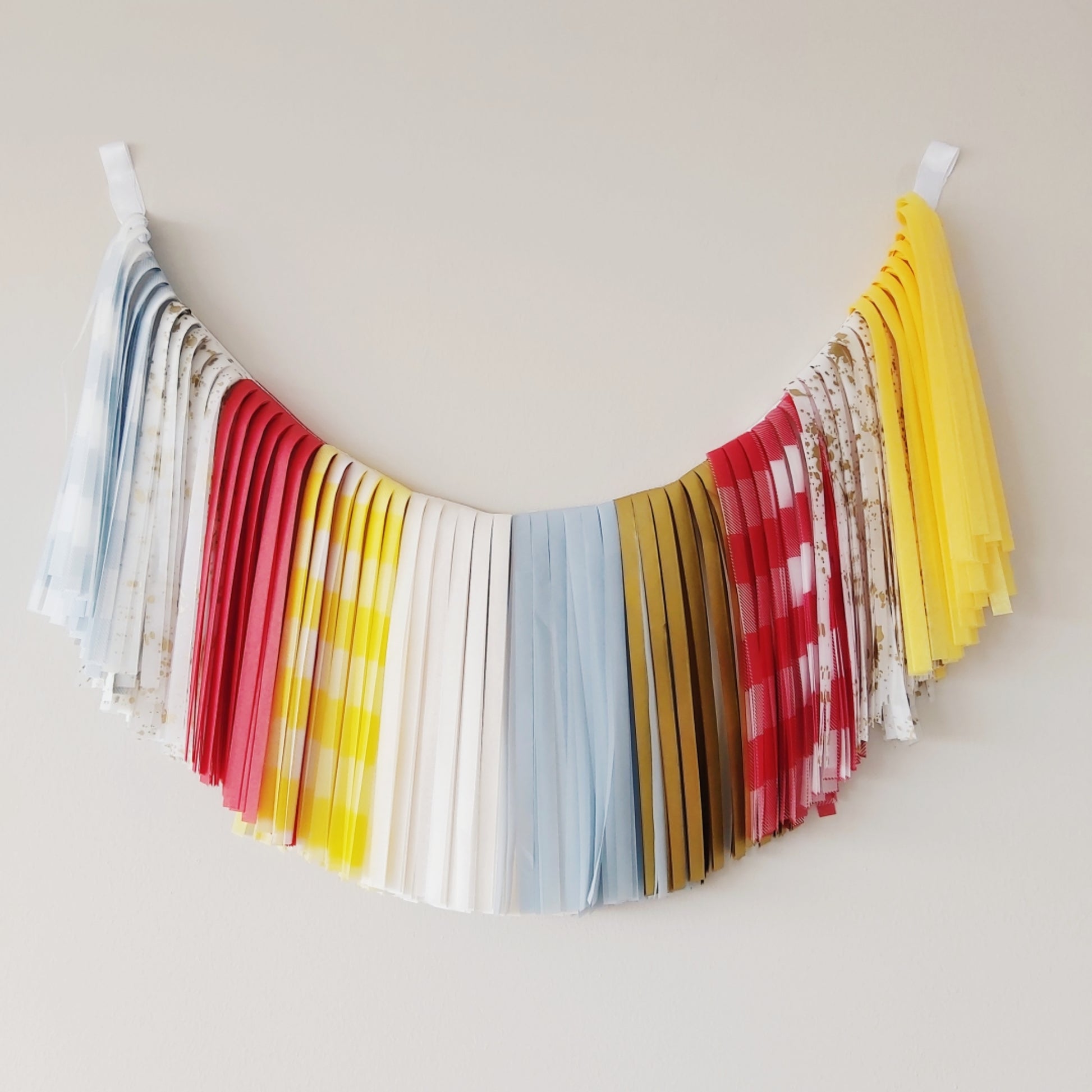 Colorful fabric banner hanging against a plain wall