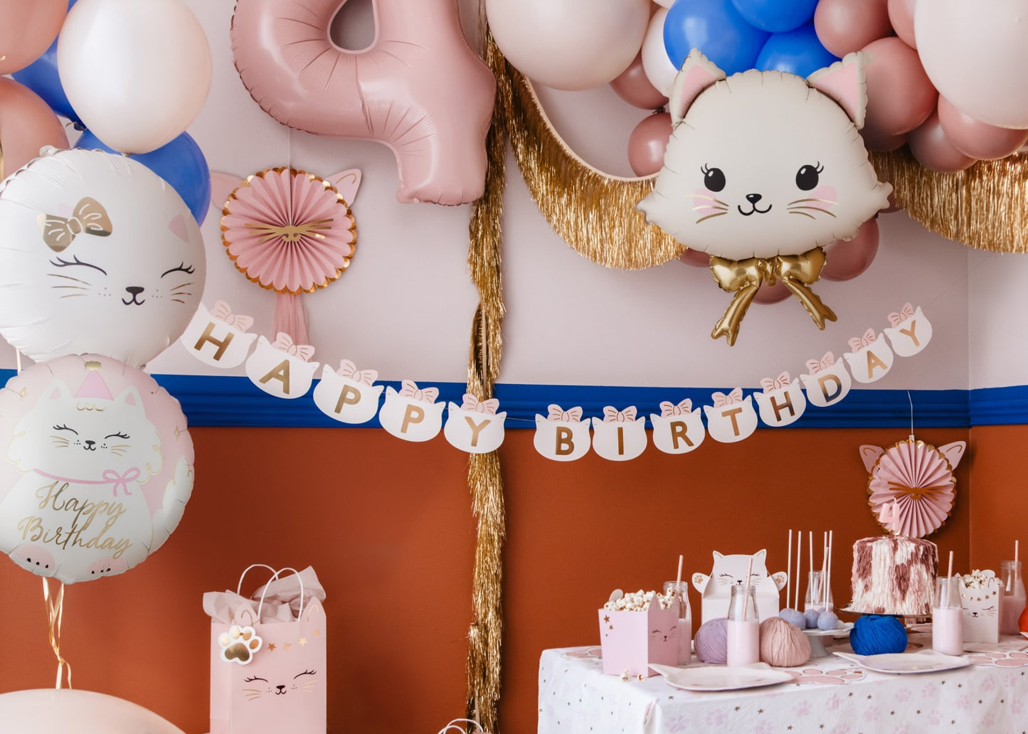 Birthday party setup with balloons, a cake, and decorations.