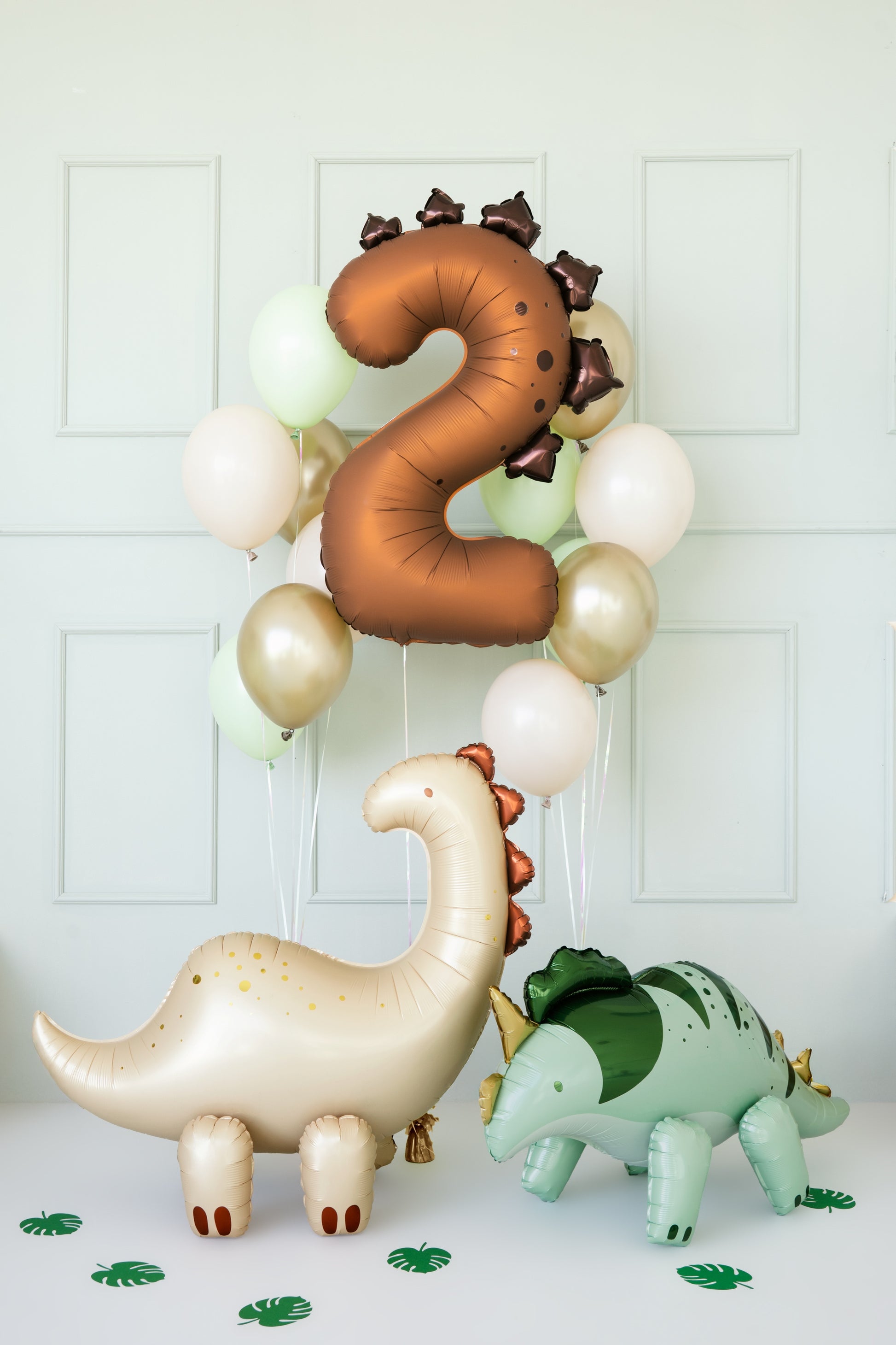 Dinosaur-themed balloons including a number '2' and three different dinosaur shapes on a white background.