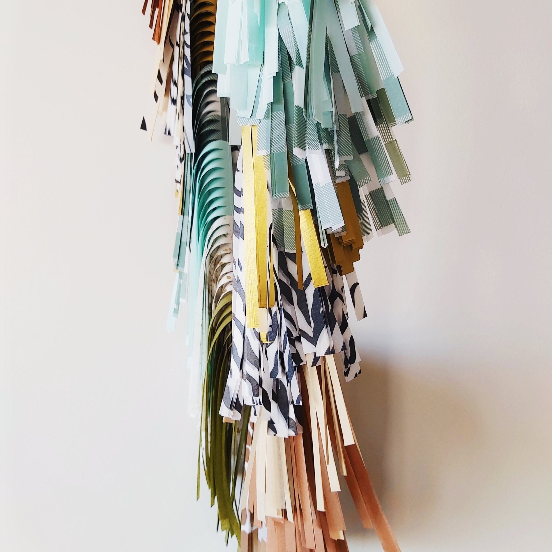 Colorful paper tassel decoration on a plain background