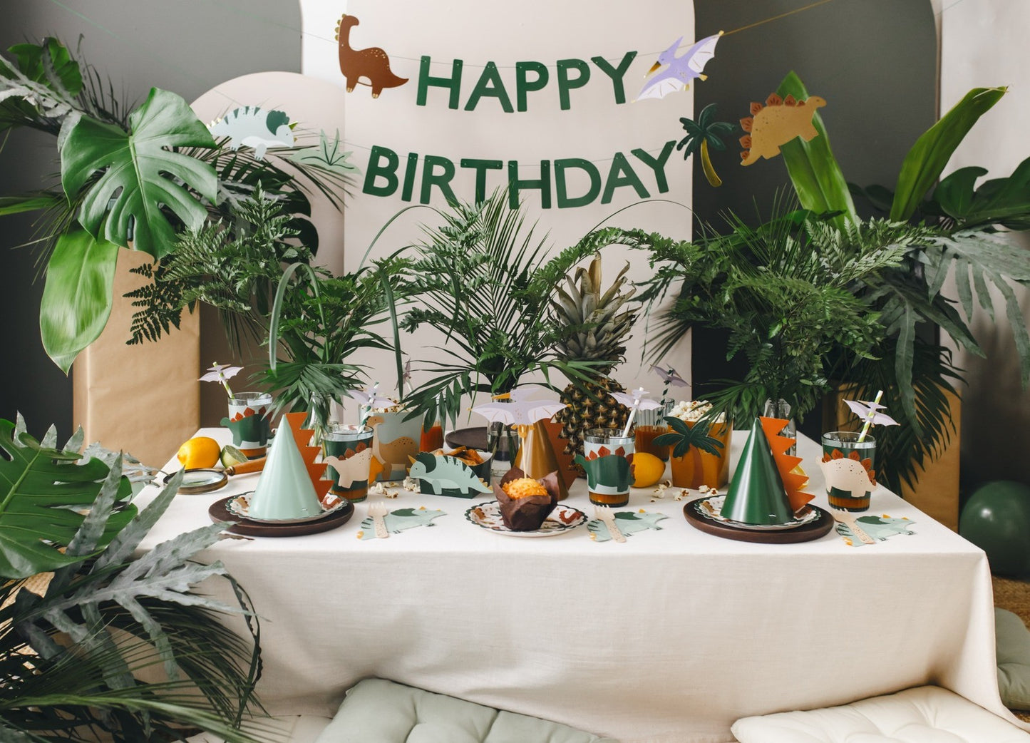 Happy Birthday banner with green dinosaurs and jungle leaves for prehistoric party decor