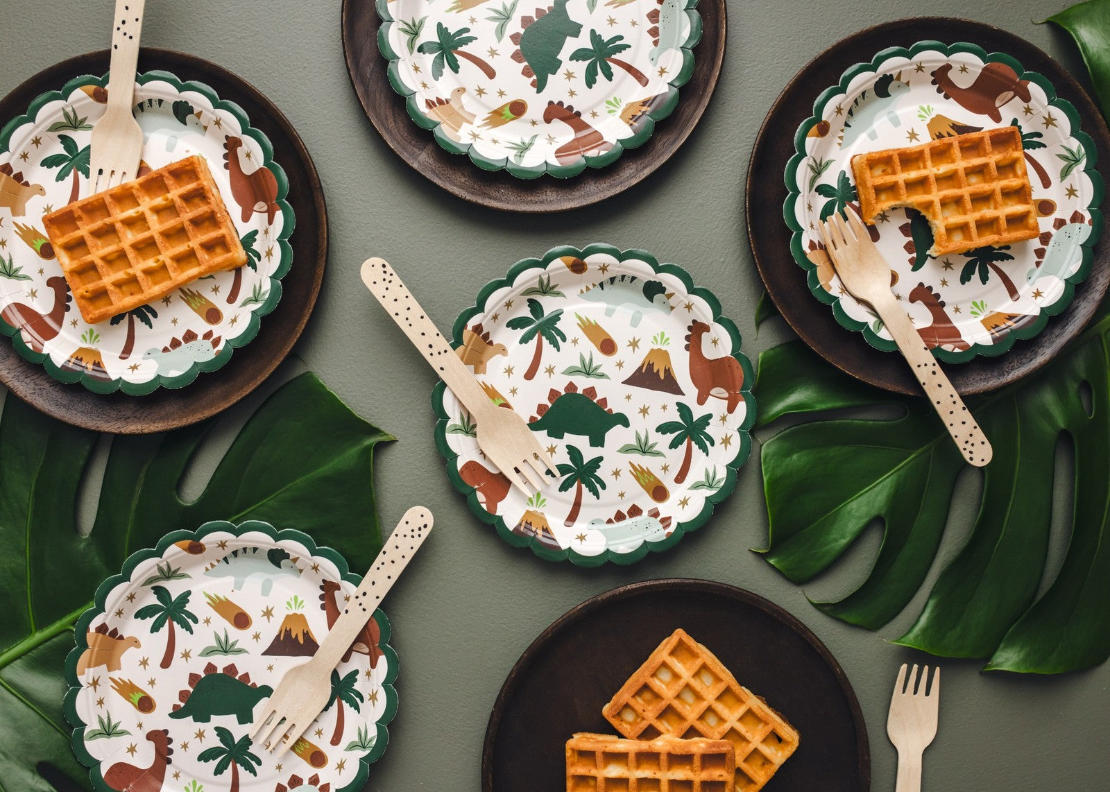 Round dinosaur-themed paper plates with colorful illustrations for kids birthday party