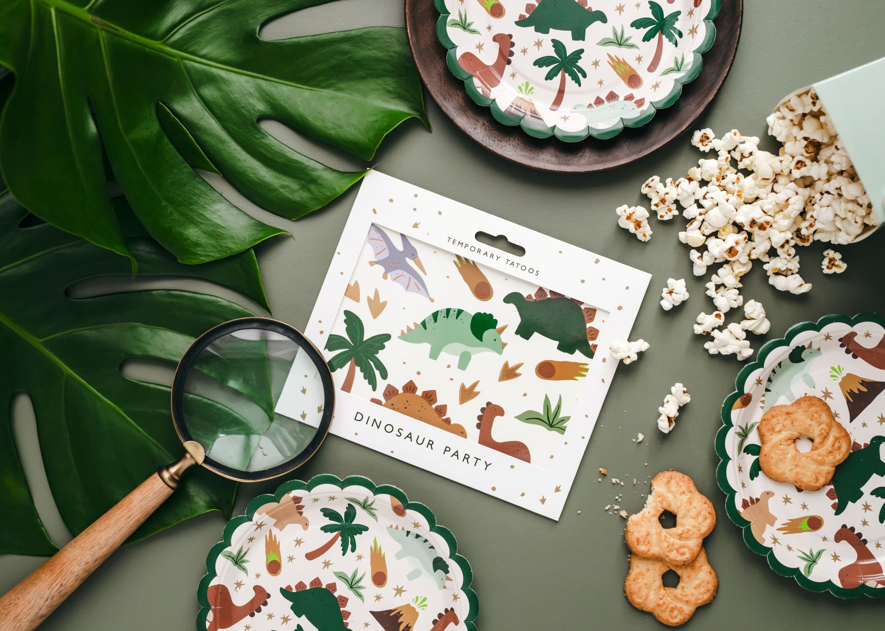 Dinosaur paper plates with cookies, temporary tattoos and a popcorn snack box