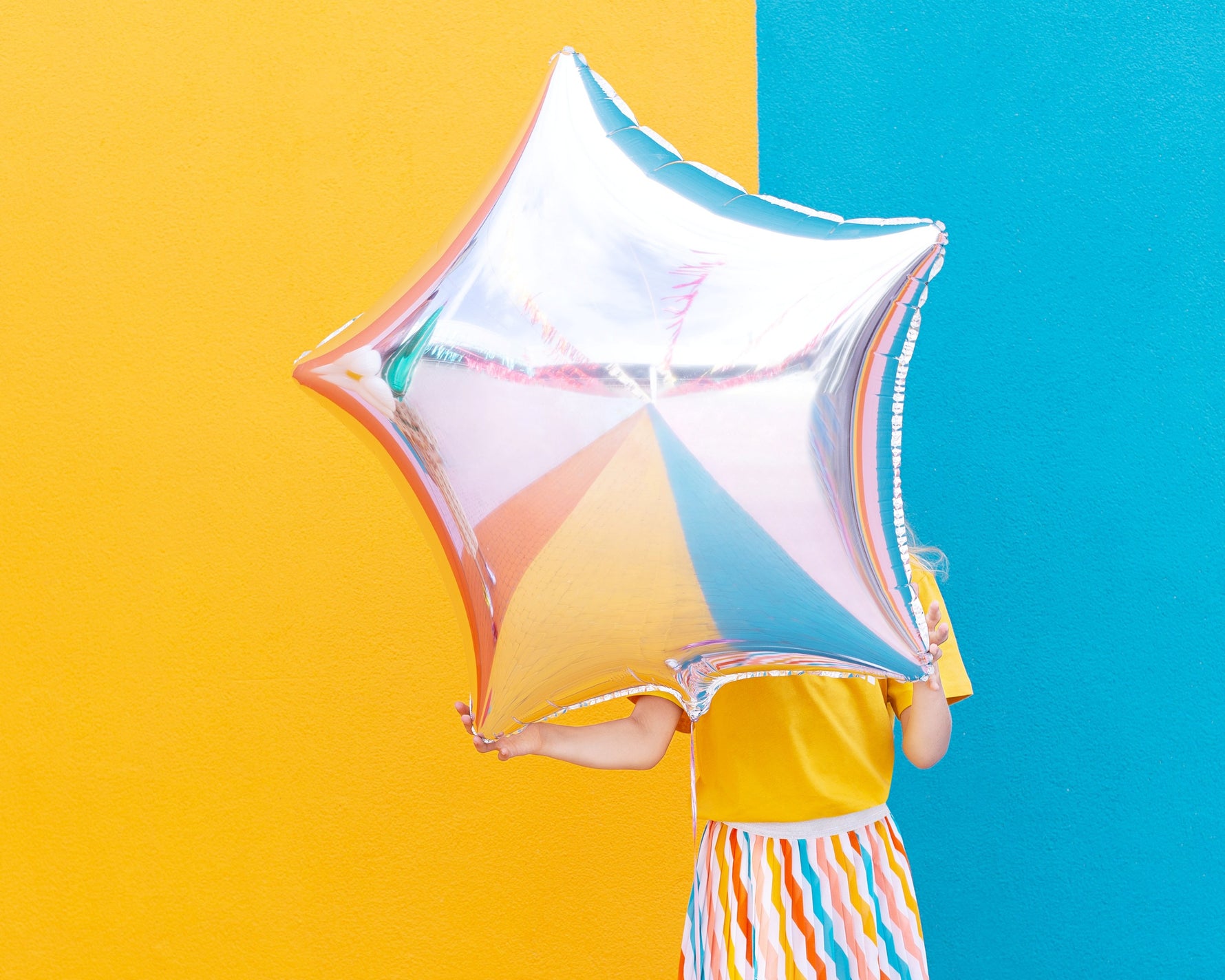 Person holding a big, star-shaped foil balloon.
