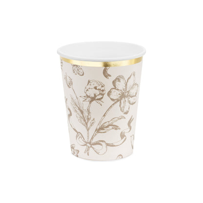 White paper cup with gold floral pattern on a white background