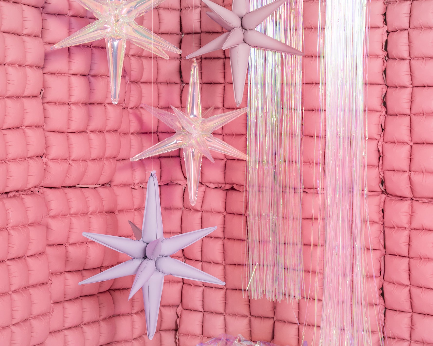 Foil star balloons and pink backdrop.