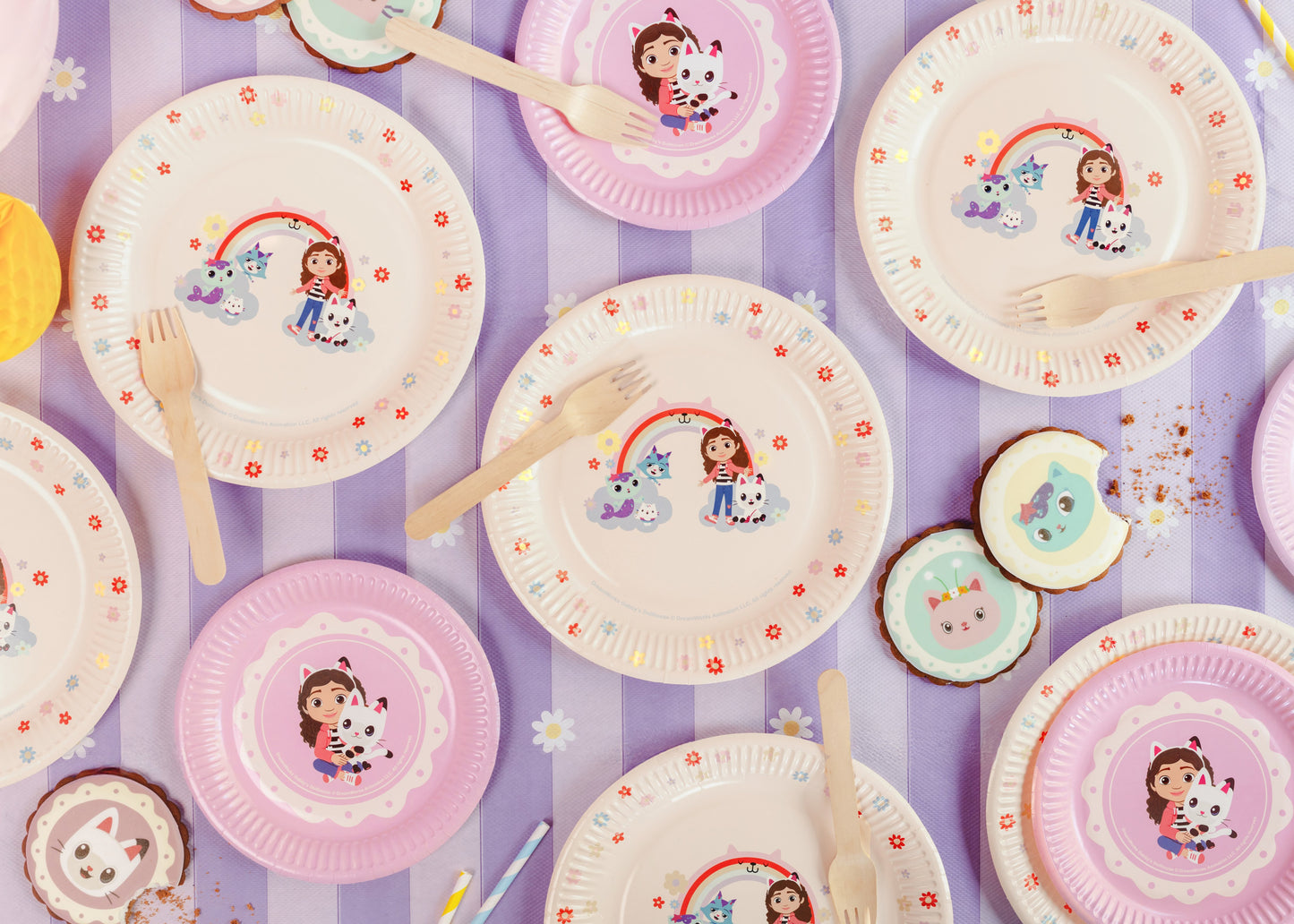 Colorful paper plates with cartoon characters on a purple striped background