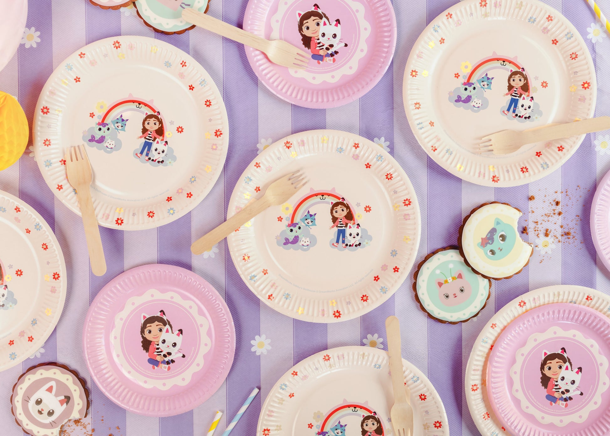 Colorful paper plates with cartoon characters on a purple striped background
