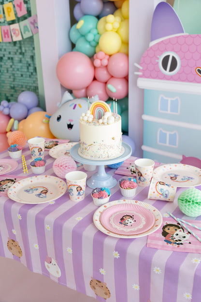 Children's birthday party setup with a cake, balloons, and themed tableware.