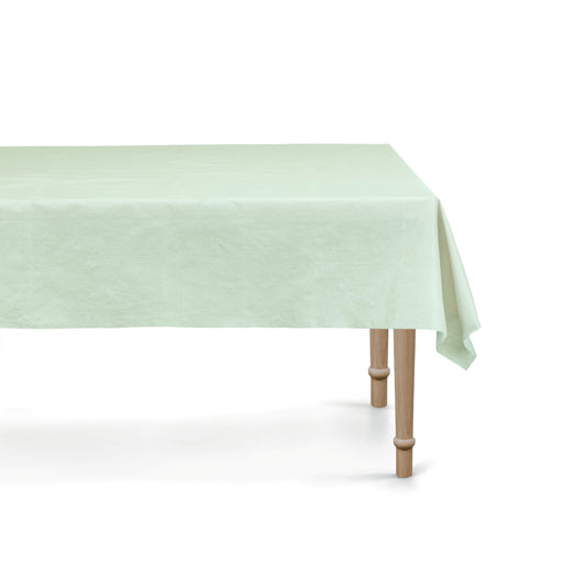 Light green tablecloth on a wooden table with a white background