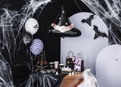 Halloween-themed party setup with balloons, treats, and decorations.