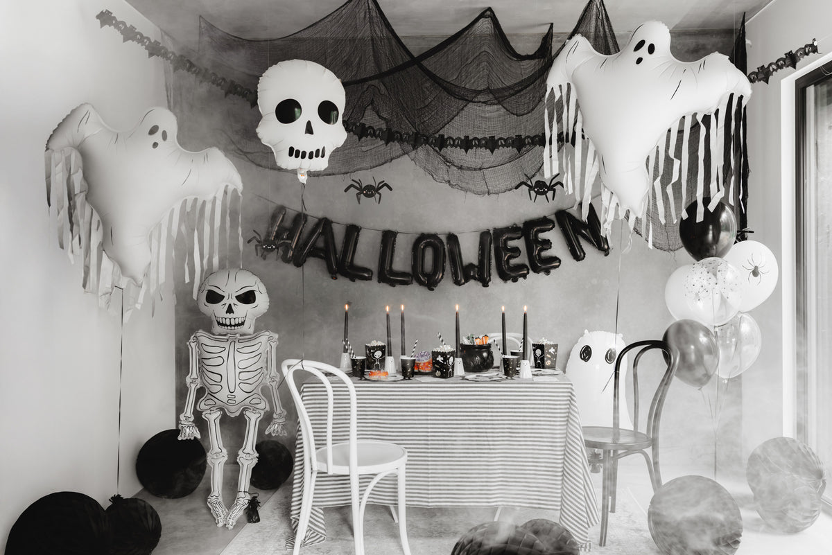 Halloween-themed room with decorations including ghosts, a skeleton, and balloons.