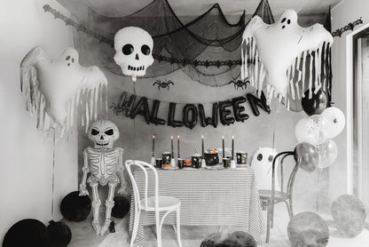 Halloween-themed room with decorations including ghosts, a skeleton, and balloons.