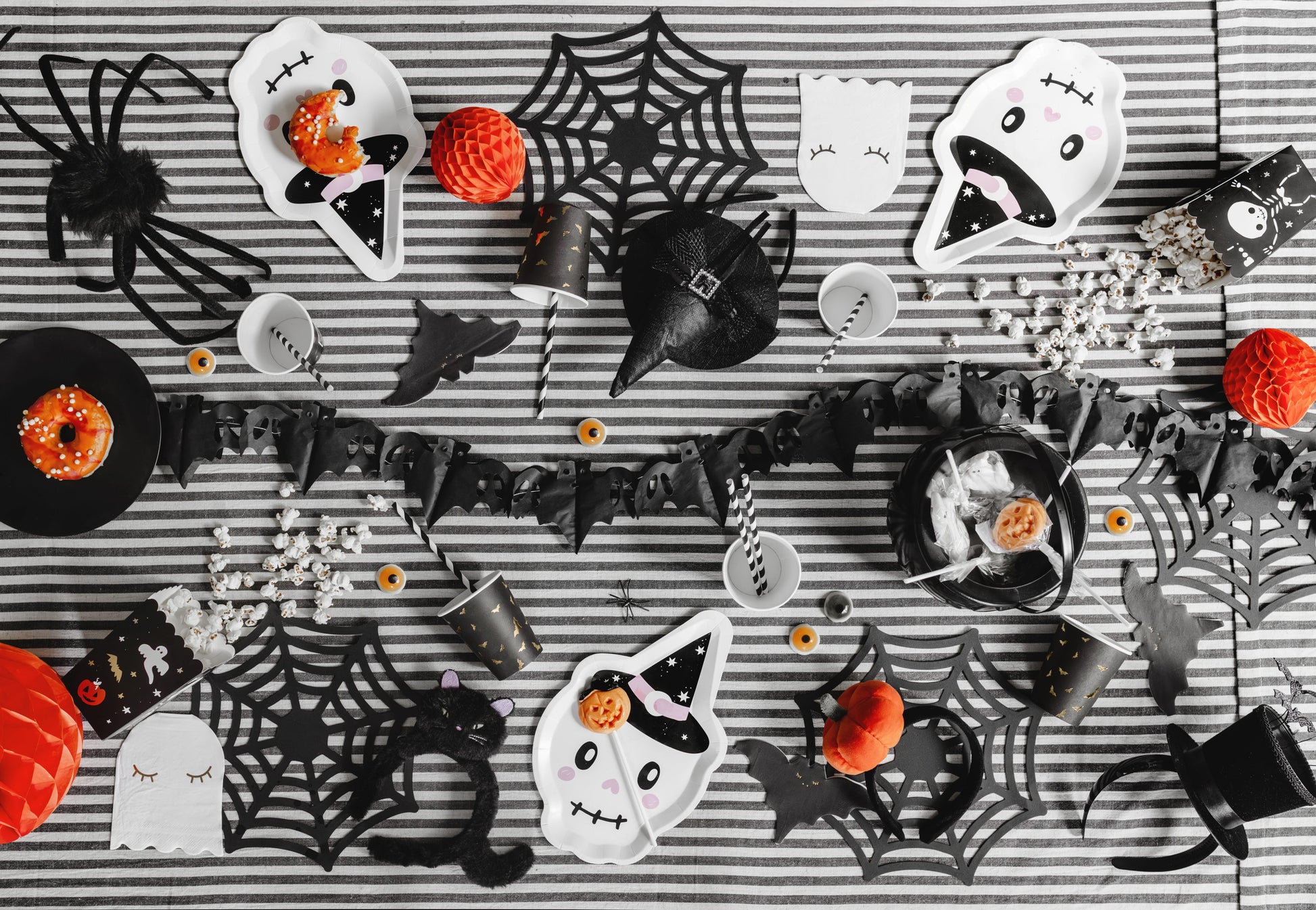 Halloween-themed treats and decorations on a striped background
