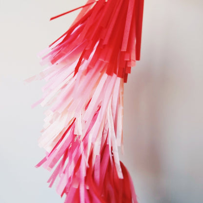 Close-up of red and pink tinsel strands against a blurred background