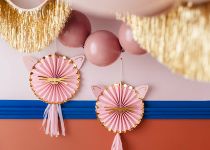 Pink decorative rosettes with gold accents on a colorful background