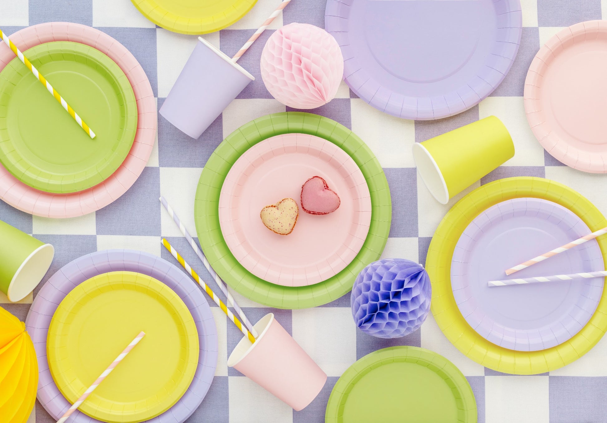 Colorful paper plates and cups on a checkered tablecloth