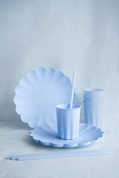 Light blue scalloped plates and cups on a light gray background