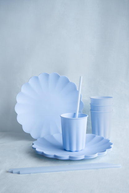 Light blue scalloped plates and cups on a light gray background