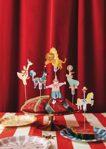 Set of six circus-themed cupcake toppers featuring a clown, seal with ball, zebra with balloons, lion jumping through a hoop, carousel horse, and goose with a red bow