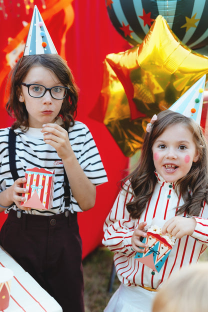Popcorn or snack boxes with circus tent patterns in red, blue, and pastel designs decorated with stars and bows