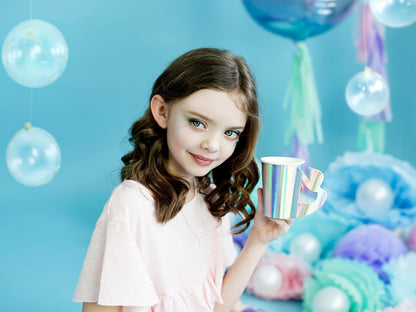 Iridescent paper cups with mermaid tail-shaped handles — ideal for kids' ocean-themed parties.
