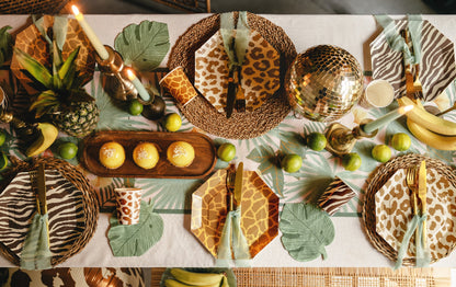 Decorative table setting with animal print plates, gold accents, and greenery.