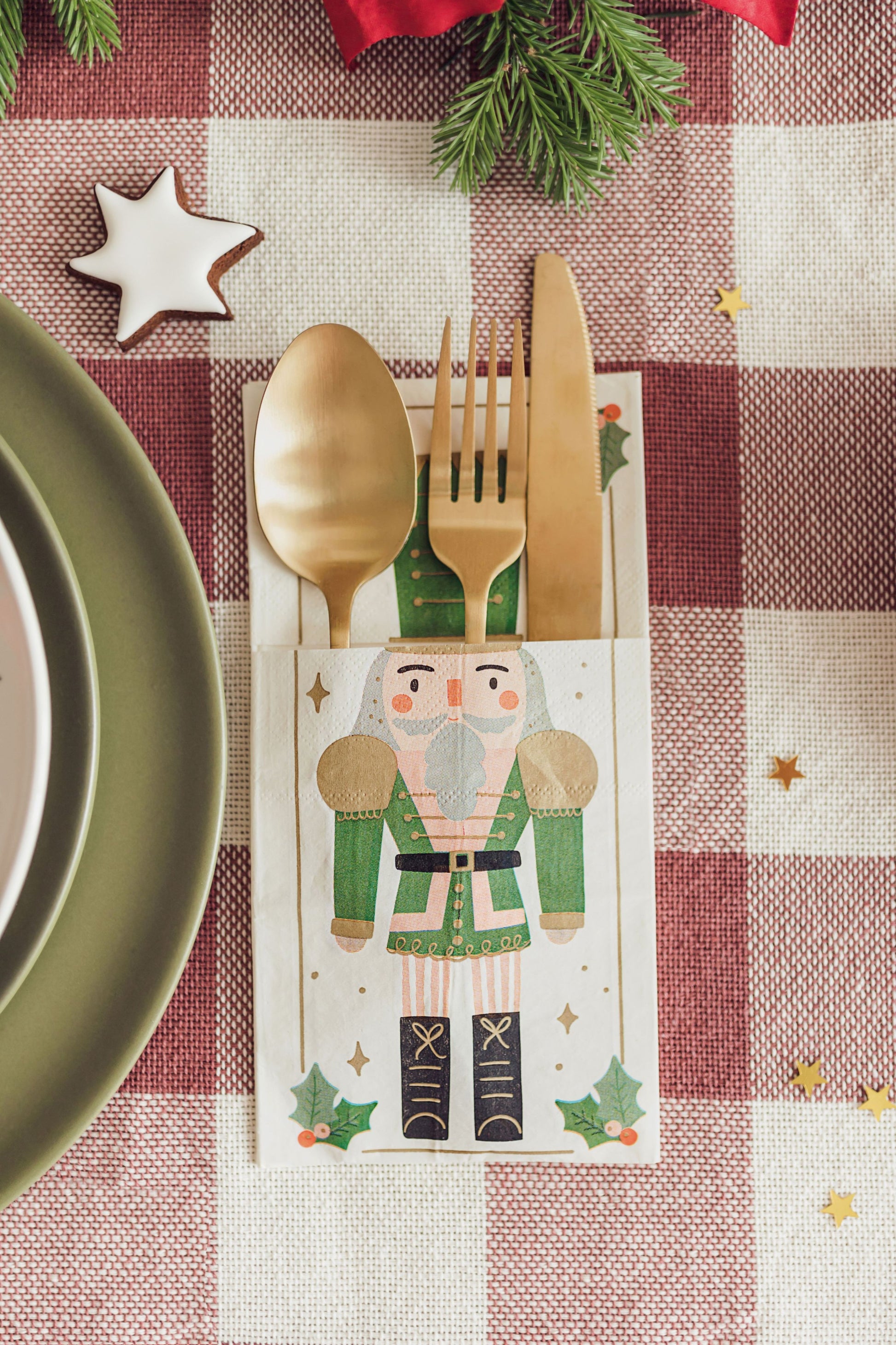 Christmas-themed cutlery holder with a nutcracker design on a checkered tablecloth.