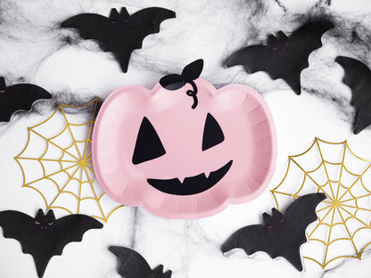 Pink paper plate shaped like a jack-o'-lantern with black bats and spider webs on a white background