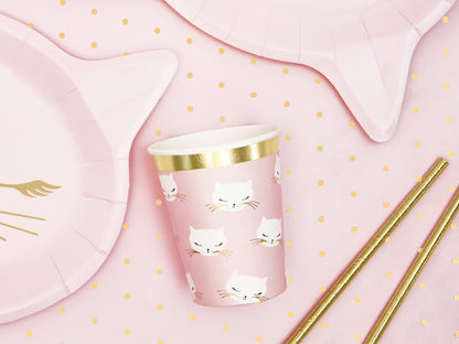 Pink paper cups with cute kitty faces and gold trim, ideal for drinks at cat-themed birthday parties.