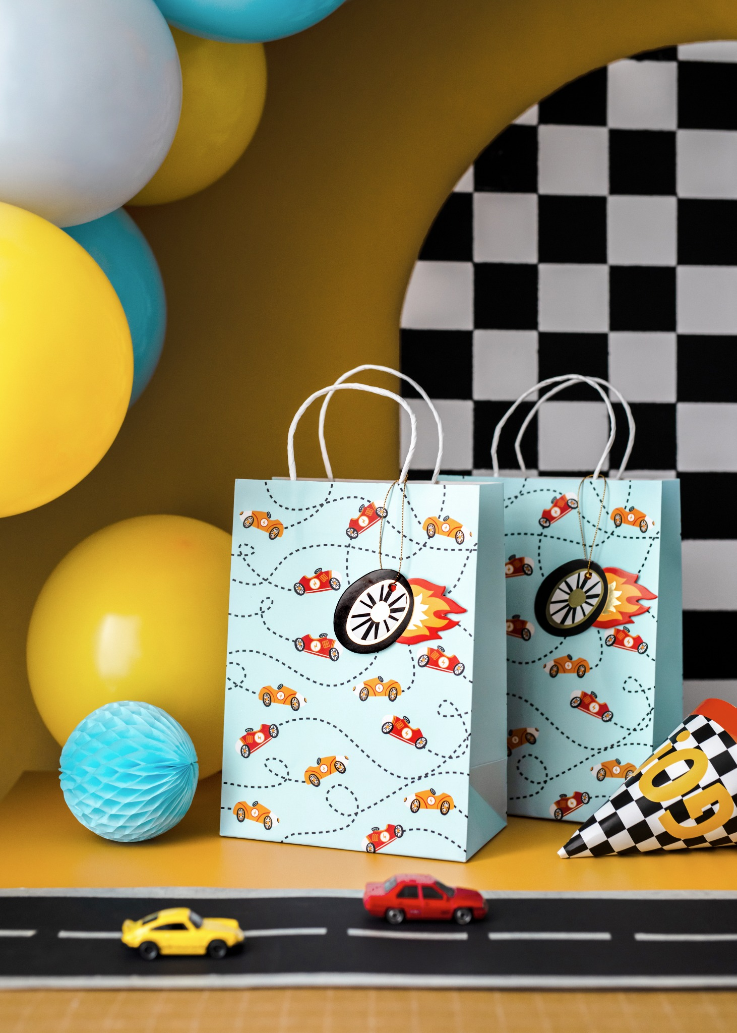 Gift bag decorated with colorful race cars and flames.