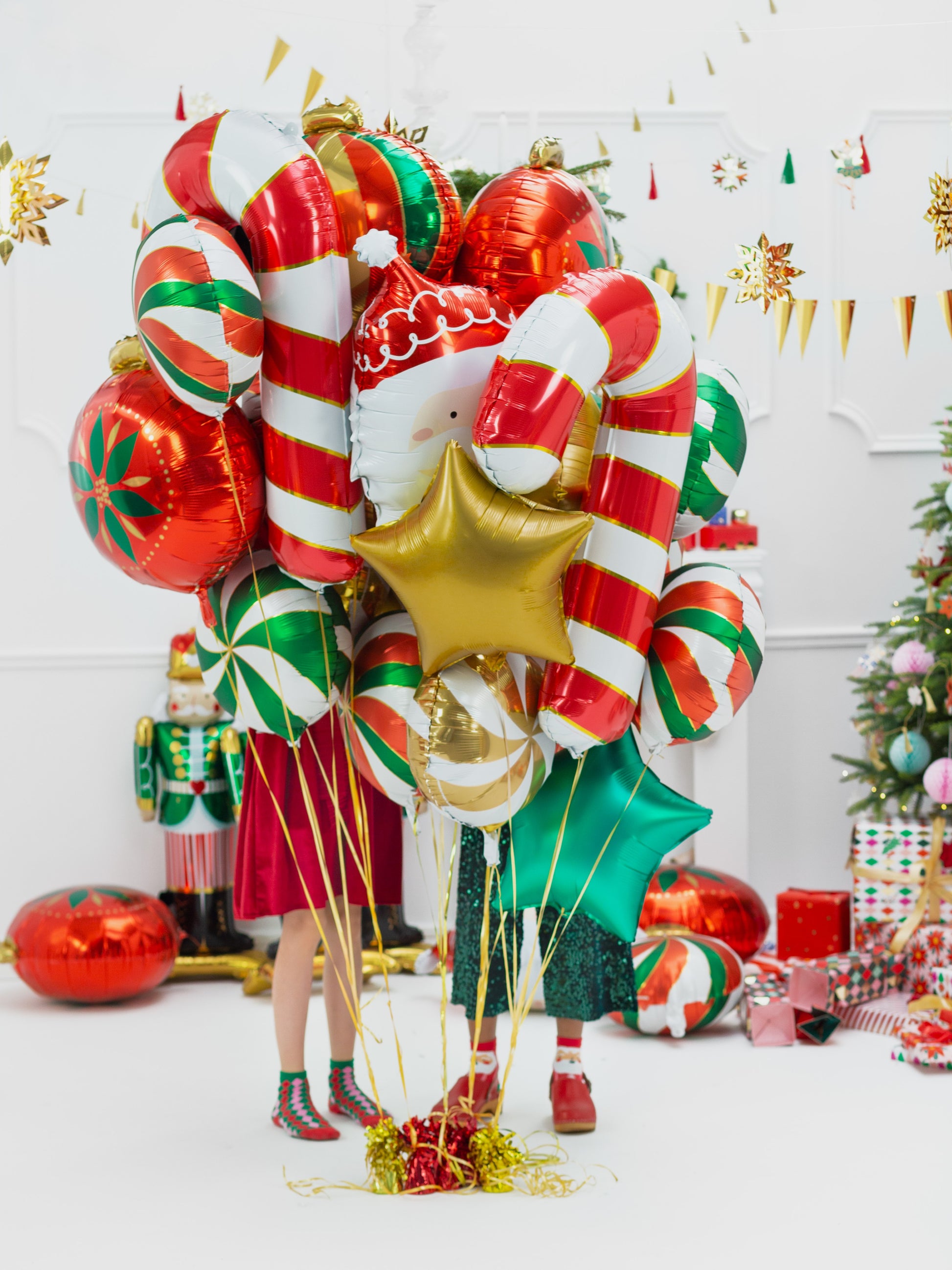 Decorative Christmas balloon arrangement with candy cane, star, and gift shapes in a festive setting.
