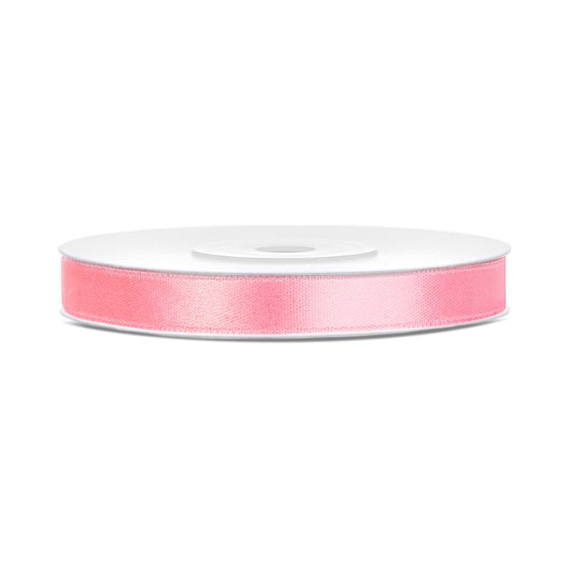 Roll of pink satin ribbon on a white background