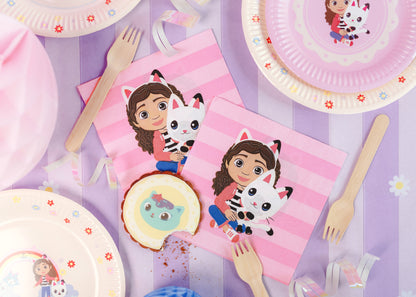 Children's party tableware with cartoon character plates, napkins, and cutlery on a striped background.