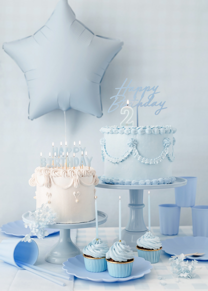 Blue themed table set up with blue happy birthday topper and blue happy birthday candles