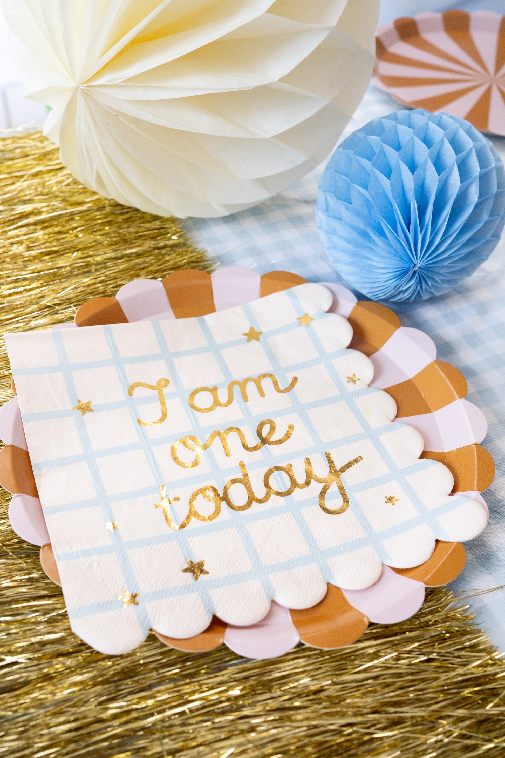 Party napkins with pastel checkered design and 'I am one today' gold foil text, ideal for first birthday celebrations