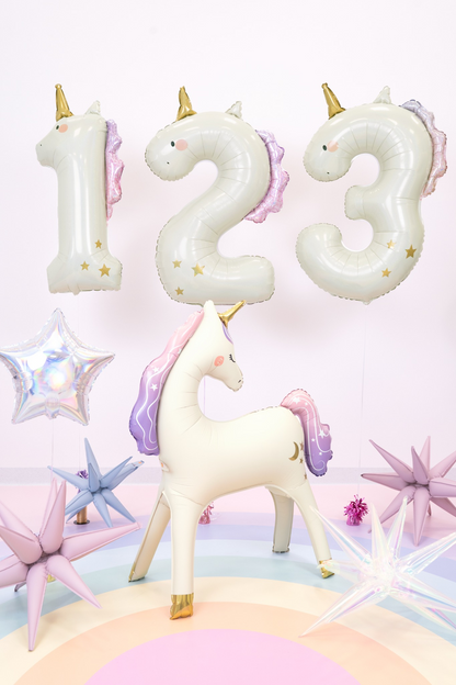 Unicorn-shaped number balloons with a small unicorn figurine on a colorful background