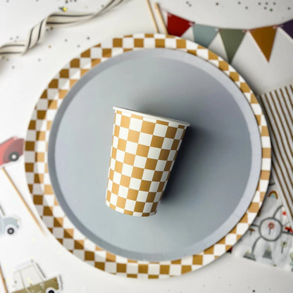 Checkered paper cup on a gray plate with a decorative background